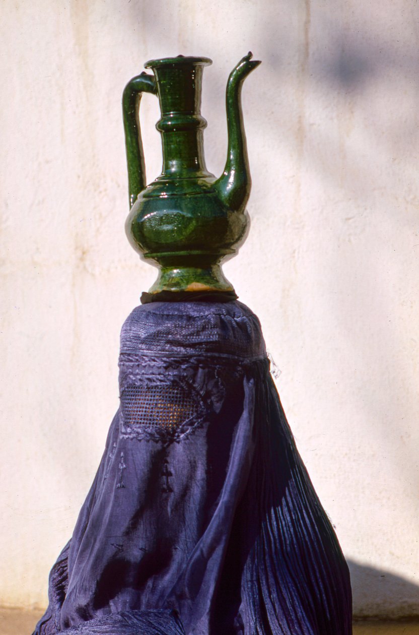 Uma mulher em Cabul, isolada do olhar por um chador de seda, transporta um jarro de uma... de Thomas J. Abercrombie