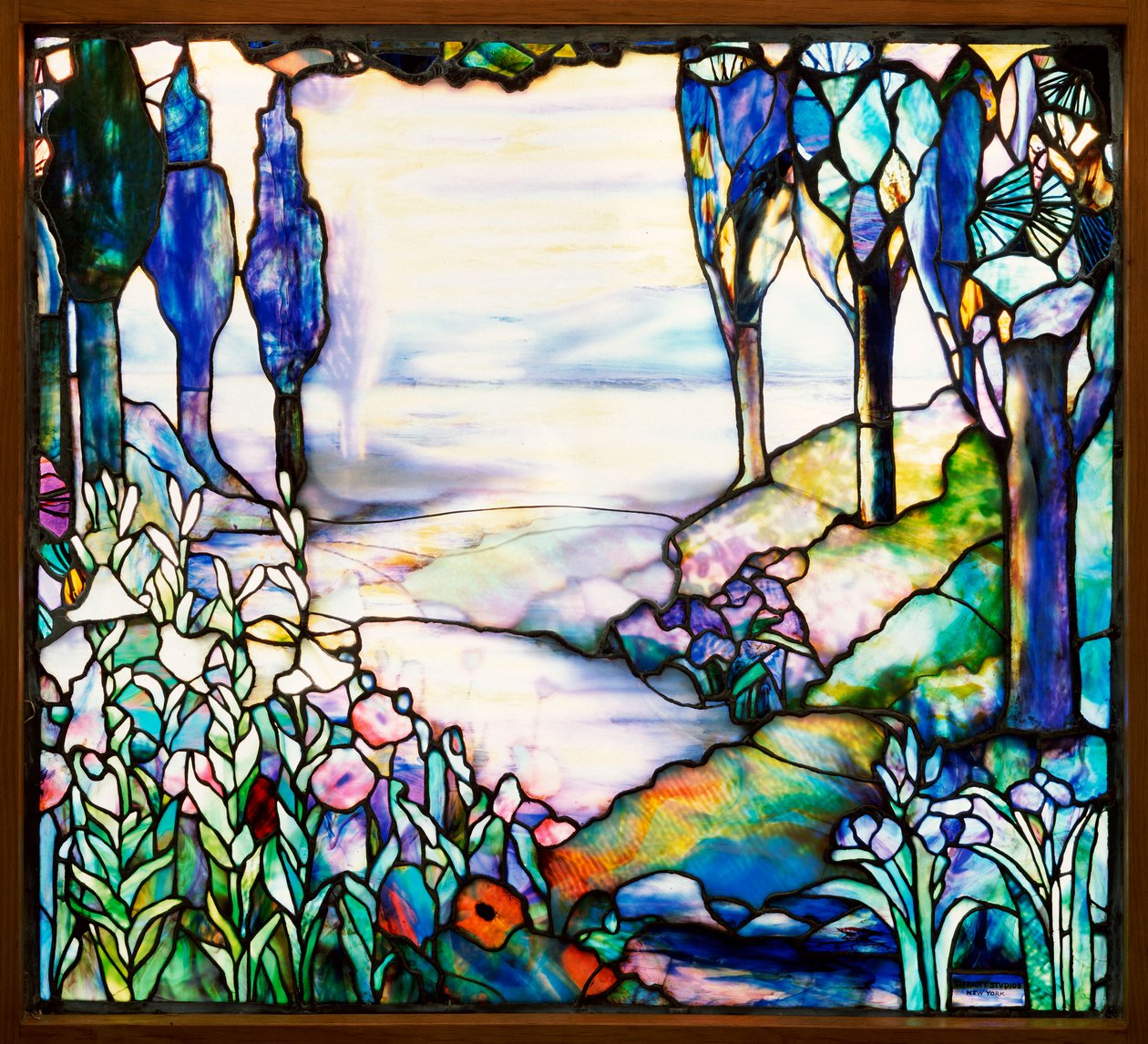 Janela de paisagem retratando um rio serpenteando de uma cordilheira distante ao entardecer, com ciprestes, lírios, papoulas e íris, c.1915 (vitrais com chumbo) de Tiffany and Company