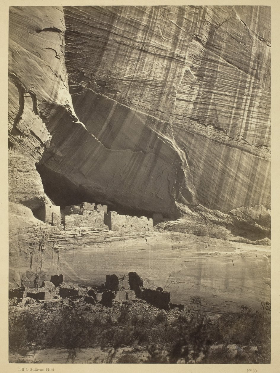 Ruínas antigas no Canyon de Chelly, NM, em um nicho a 15 metros acima da cama Canyon atual, 1873 de Timothy OSullivan