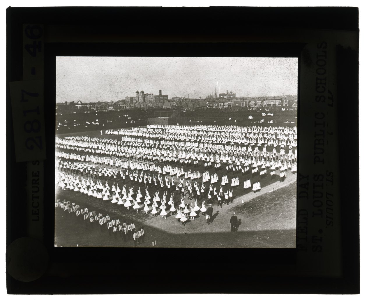A foto horizontal, preto e branco das centenas de alunos alinhou na formação para a parada e a representação histórica do dia de campo. Todas as garotas de vestidos brancos e os garotos de camisa branca e laços com calças escuras de Unbekannt Unbekannt
