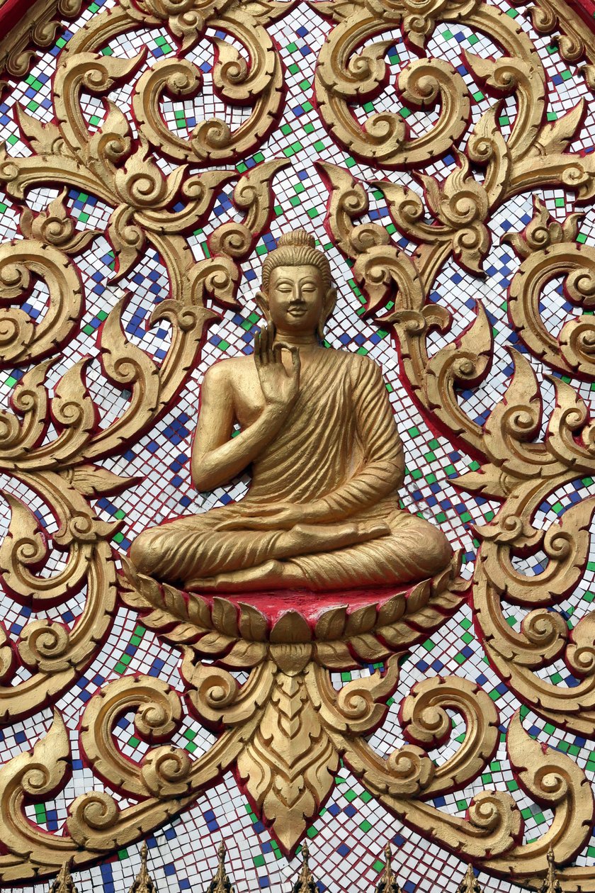 20151102, Vang Vieng, Laos : Porta de entrada ornamentada com relevos dourados. O Buda Ensinante retrata um momento particular na vida do Buda, a saber, o primeiro sermão que o Buda fez depois de alcançar a Iluminação. de Unbekannt