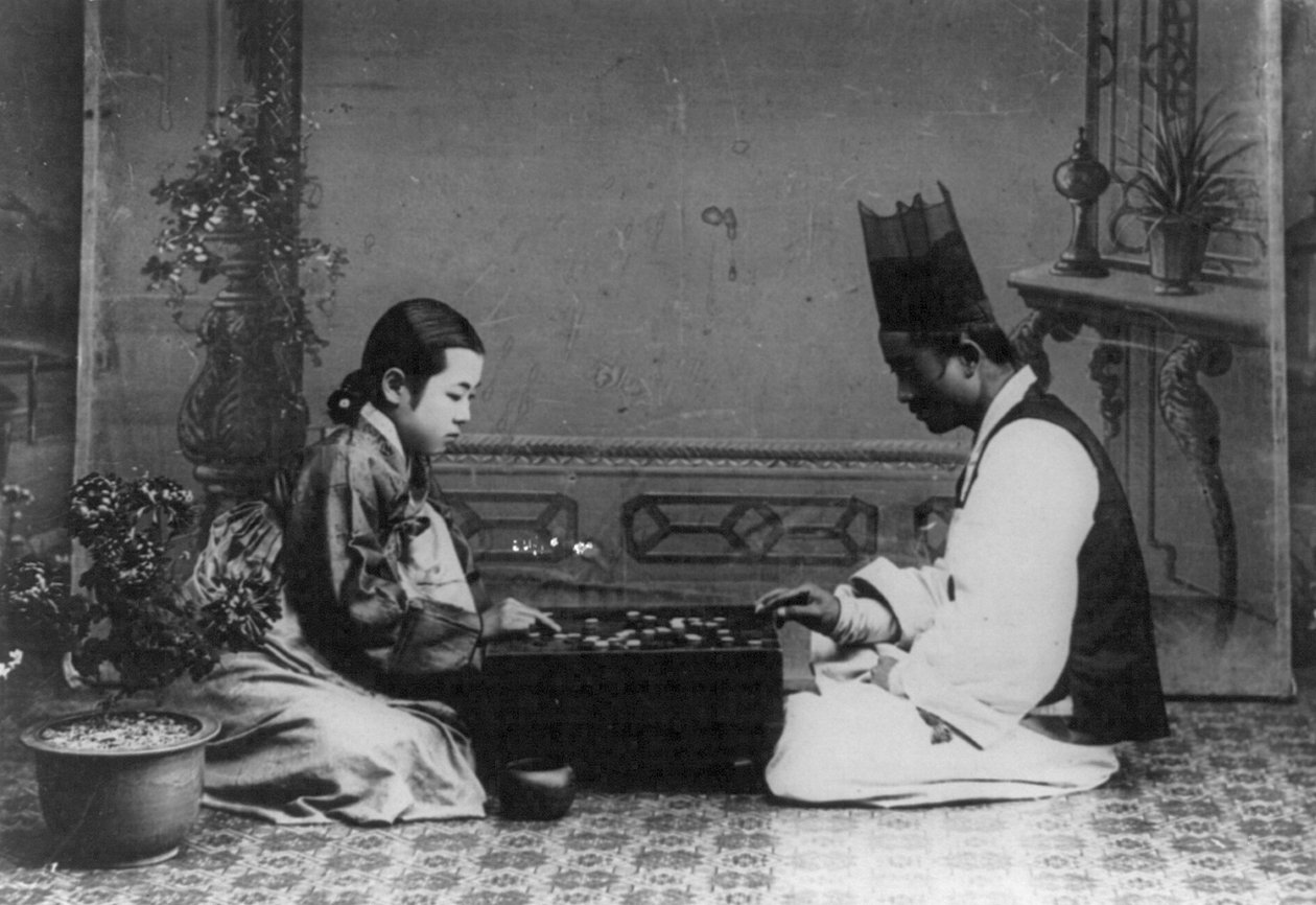 Um homem e uma mulher jogando um jogo de Baduk ou 