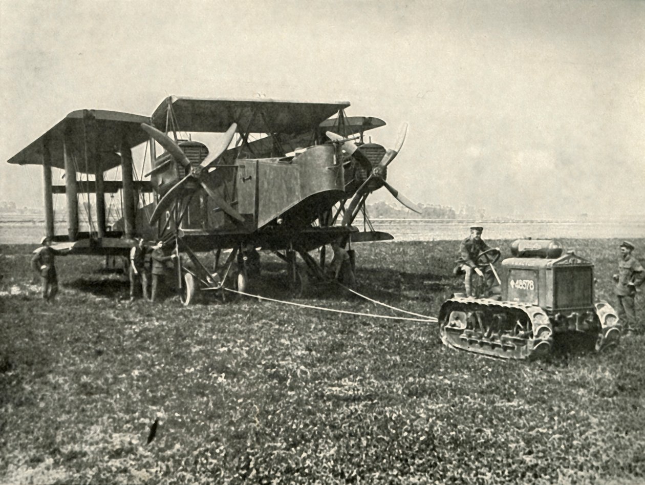 Um pequeno trator a motor colocando uma enorme máquina de bombardeio da RAF em posição ..., 1919. de Unbekannt