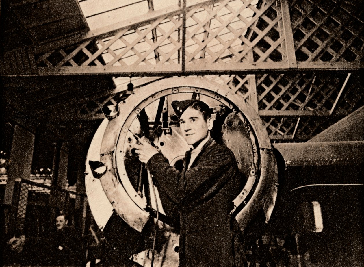 Um trabalhador de metal com broca automática descascando uma carcaça de motor, 1940 de Unbekannt