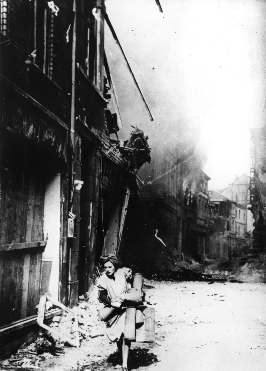 Uma mulher saindo de sua casa em chamas em uma rua bombardeada, Alemanha, 1945 de Unbekannt
