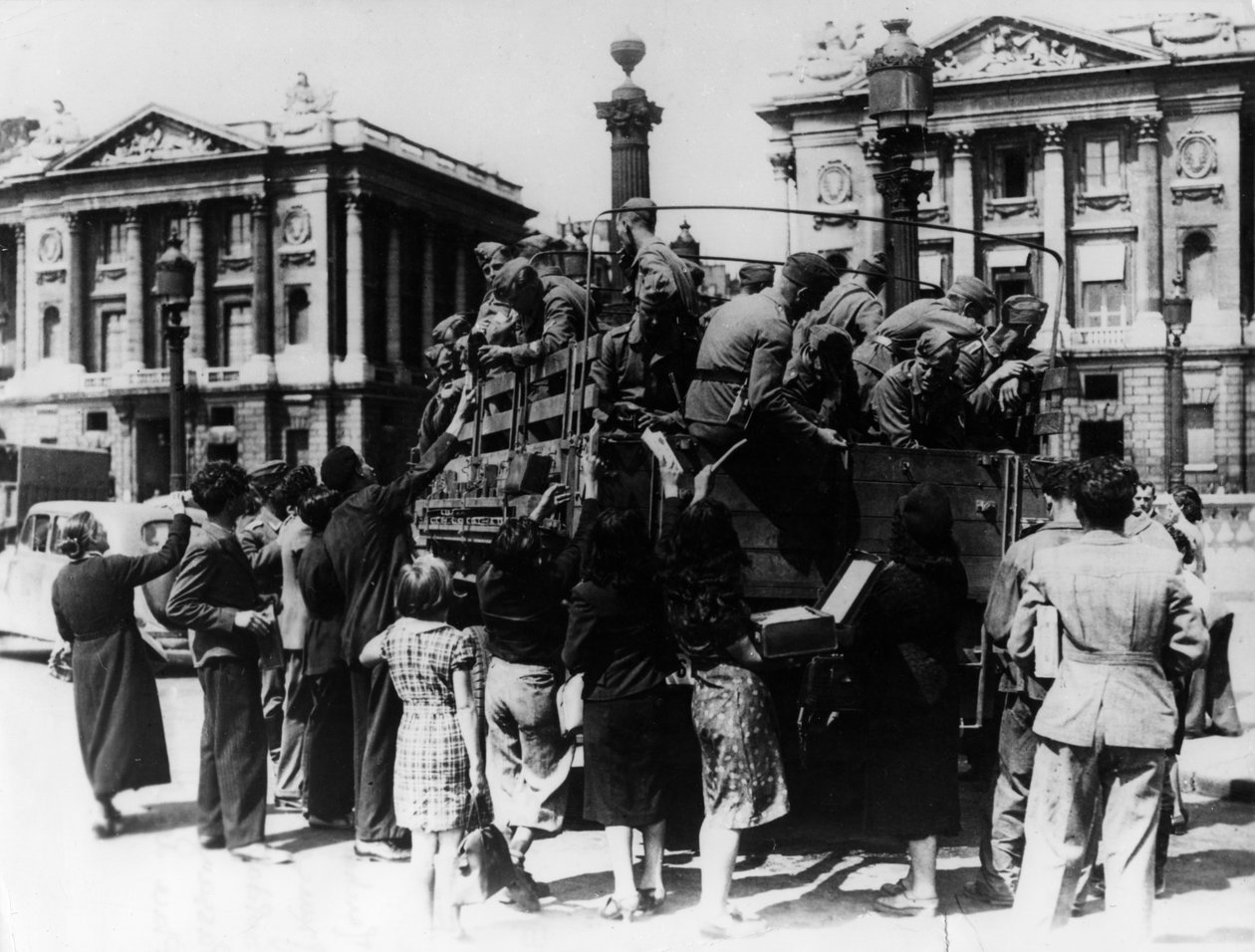Vendedores de rua franceses que oferecem lembranças a um caminhão cheio de soldados alemães, Paris, 27 de julho de 1940 de Unbekannt