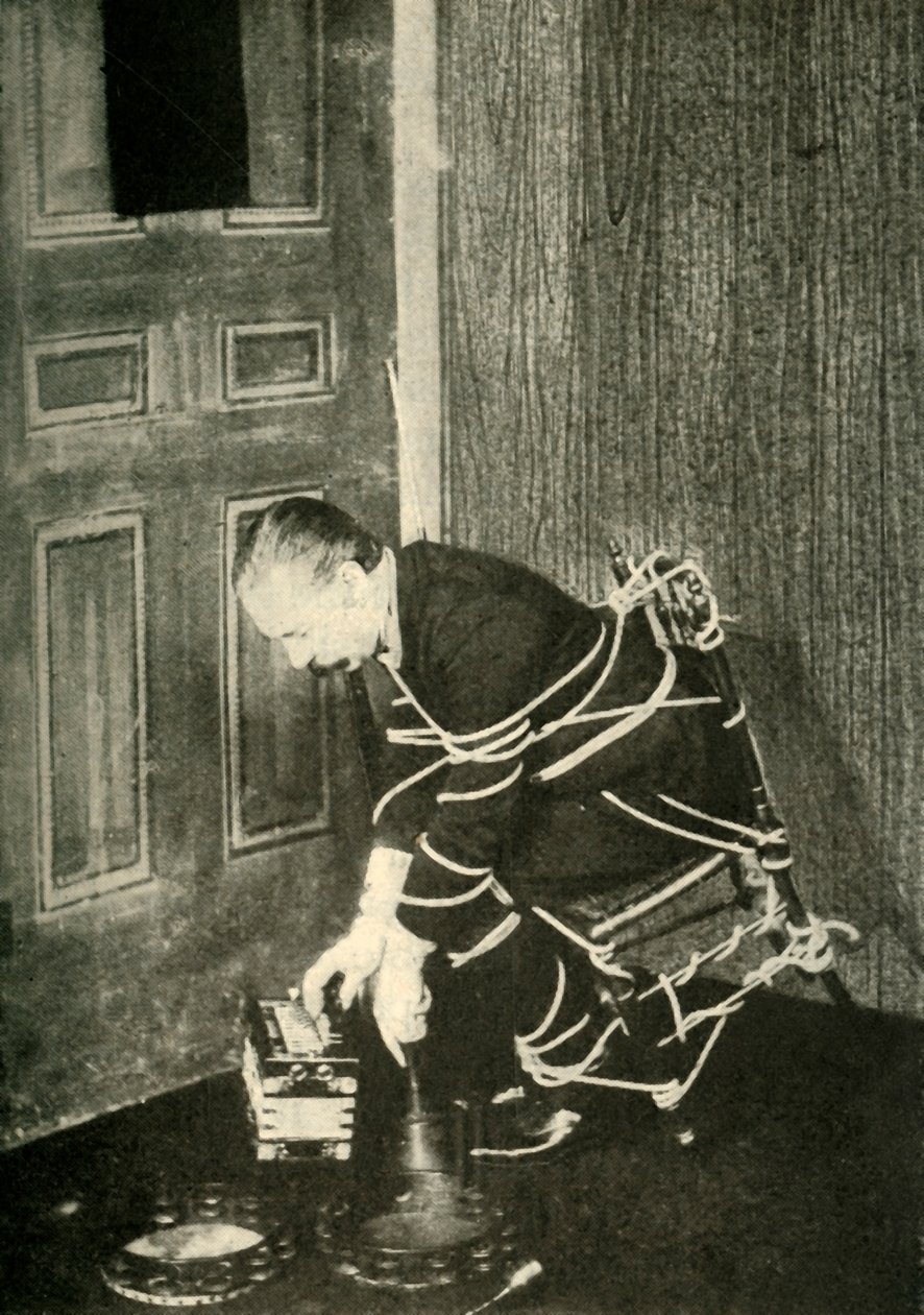 John Nevil Maskelyne realiza uma ilusão de gabinete espiritual, c1910. de Unbekannt