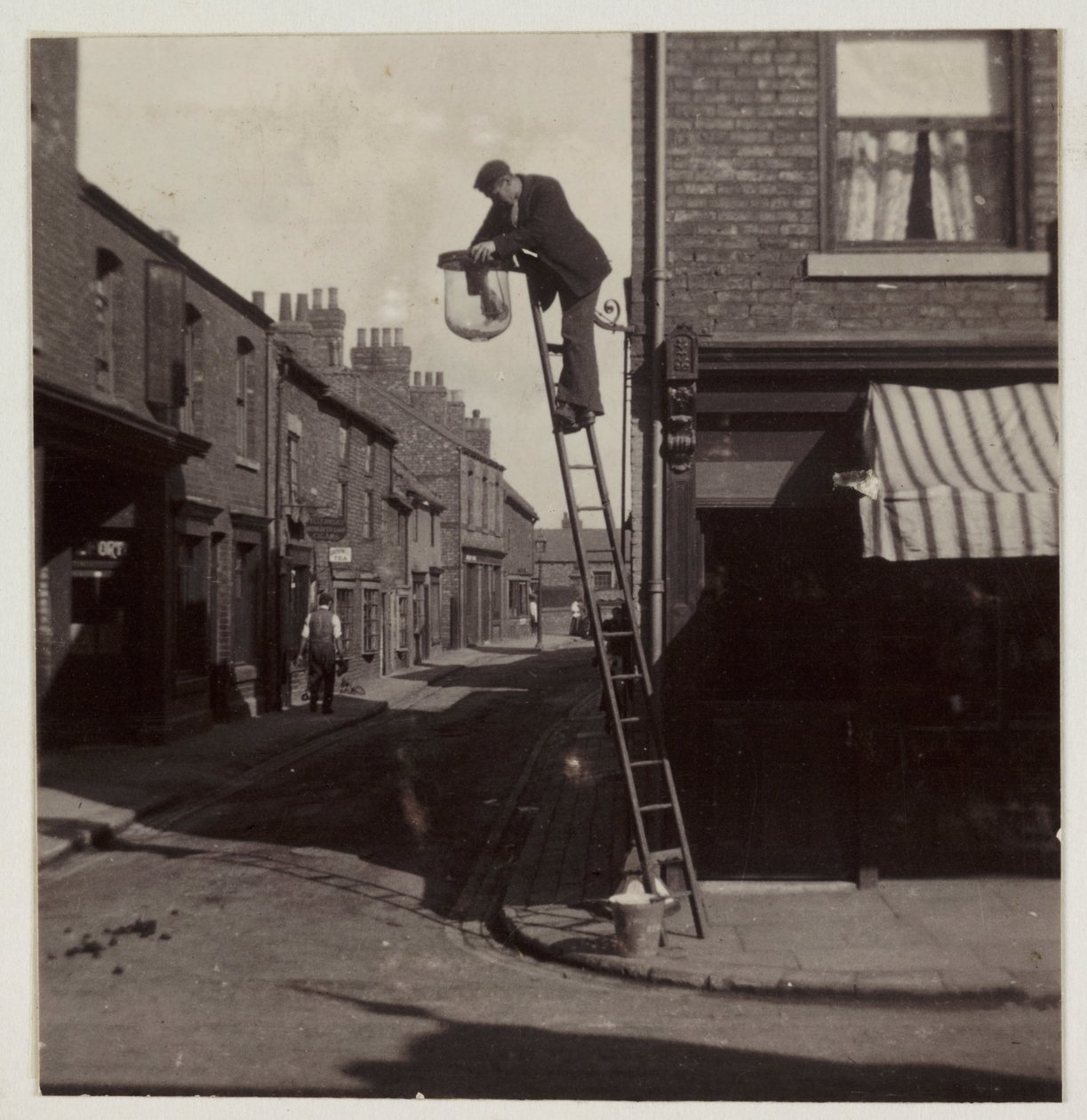 Homem limpando um semáforo de rua de gás, c 1905 de Unbekannt