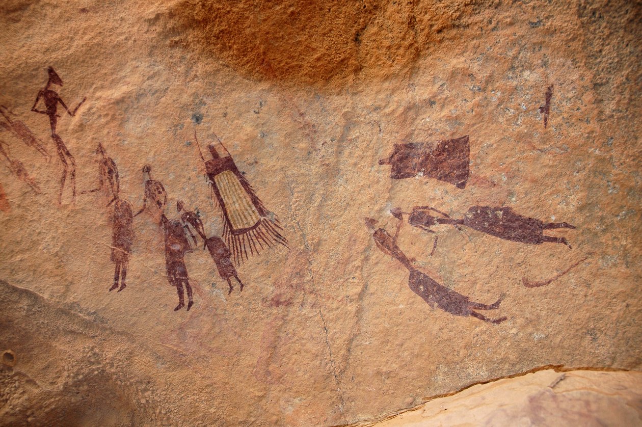 Arte rupestre, Pré-história: A pintura rupestre de um grupo de personagens e "guerbas" (exteriores) tem franjas e sem franjas num abrigo ornamentado, no maciço de Uweinat, Sudão. Período de 8000 a 3000 anos antes de Cristo. Fotografia de Unbekannt