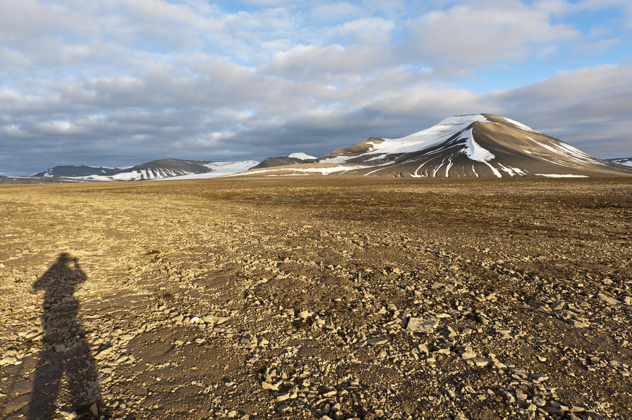 Sombra de um solo estrutural humano, poligonal, no Plataberget, pico coberto de neve Nordenskjoeldfjellet na parte de trás, perto de Longyearbyen, Spitsbergen, Svalbard, Noruega, Europa de Unbekannt
