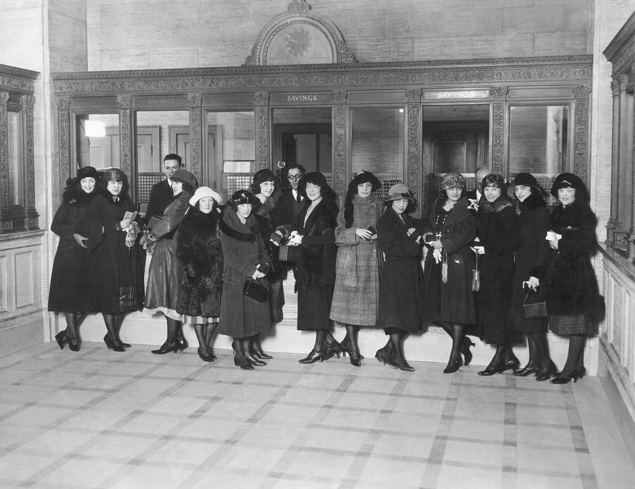 Estados Unidos: c.1926 Um grupo de mulheres de pé nos guichês de "Poupança" de um banco. (foto p/b) de Unbekannt