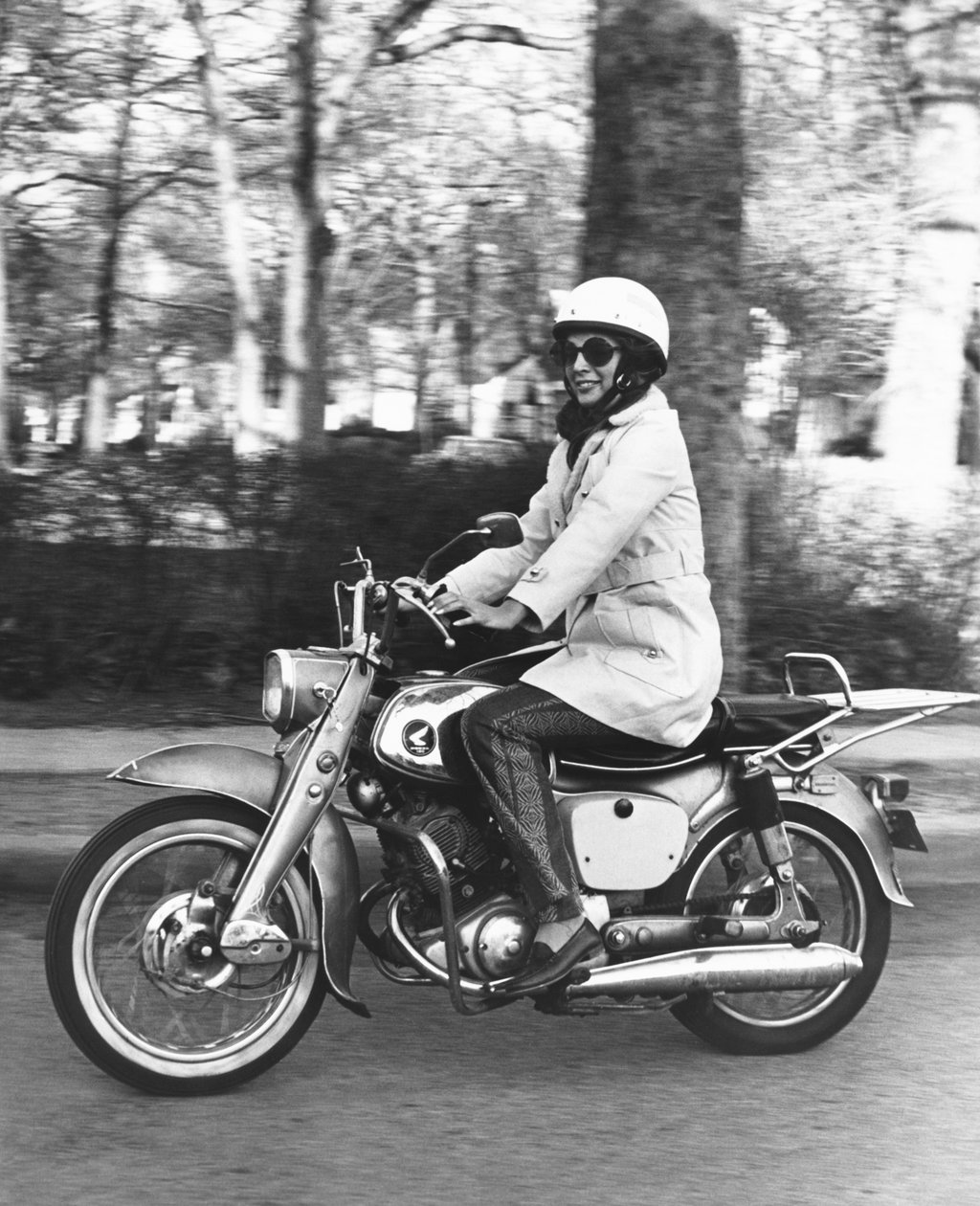 Estados Unidos: c.1961 Uma mulher pilotando sua motocicleta Honda 160. (foto a p/b) de Unbekannt