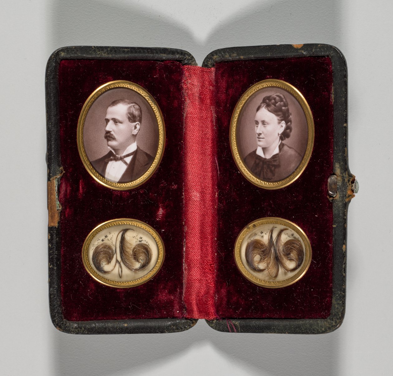 Caso sem título com retratos de ornamentos de homem e mulher e cabelo, c. 1870s. de Unbekannt