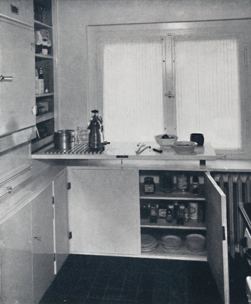 Werner Harting - Cozinha com piso de azulejo preto holandês, paredes brancas e prateleiras embutidas e cupbo de Unbekannt