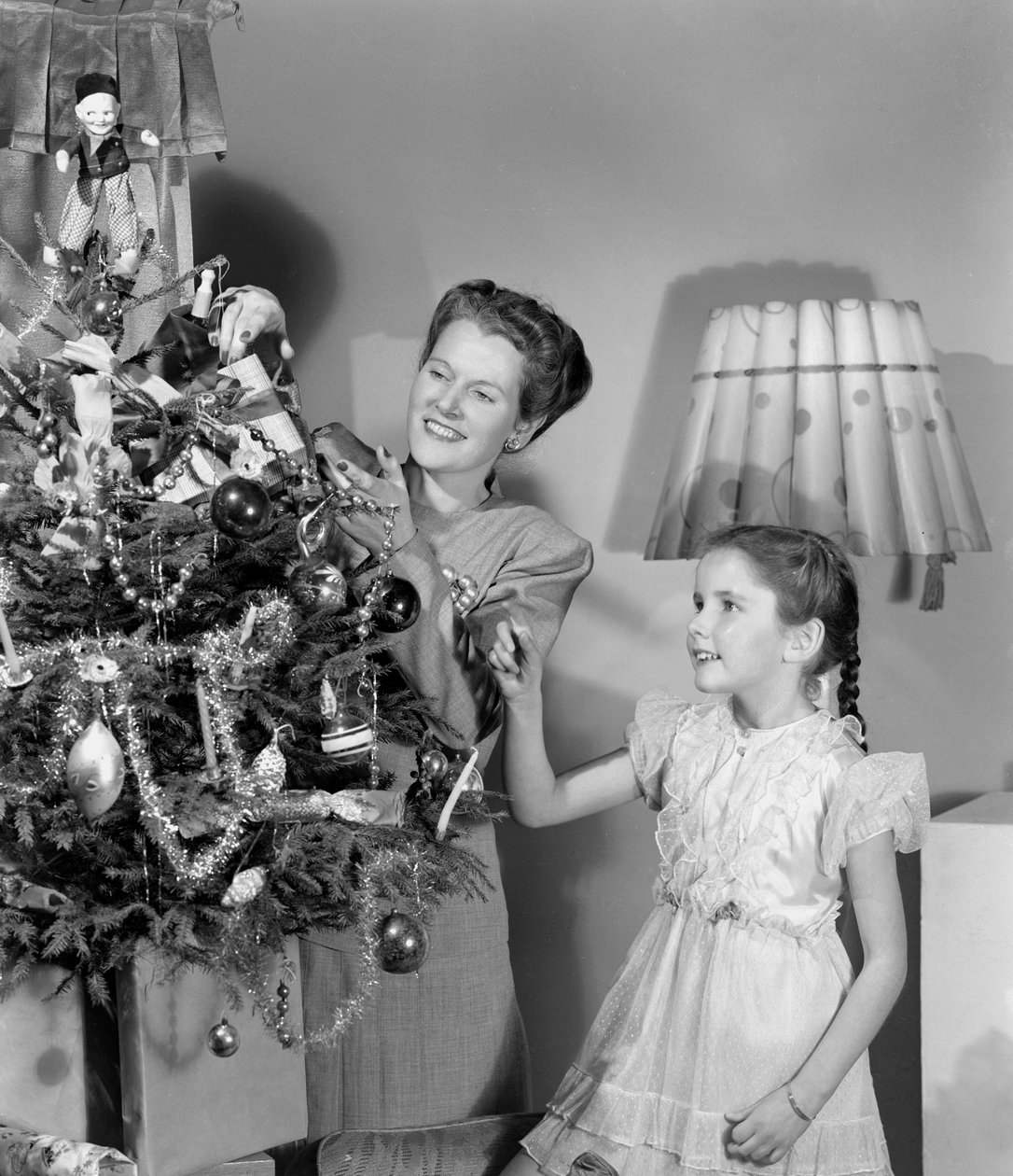 Mulher e menina decorando uma árvore de Natal, c 1948 de Unbekannt
