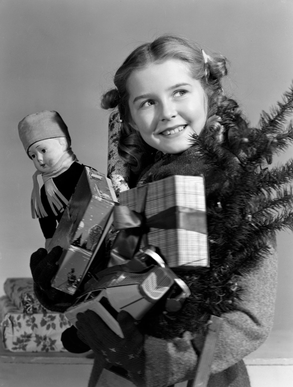 Menina com um braço cheio de presentes de Natal, c 1950 de Unbekannt