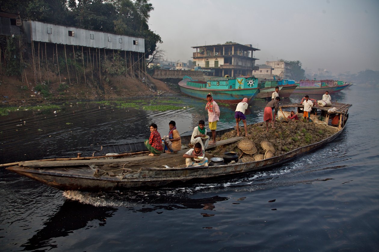 Um barco transportando terra, usado para encher a terra baixa, através do rio Shitalakhya, perto da ponte de Tongi, nos arredores da cidade de Daca. Bangladesh. 19 de fevereiro de 2007. de Unbekannt Unbekannt