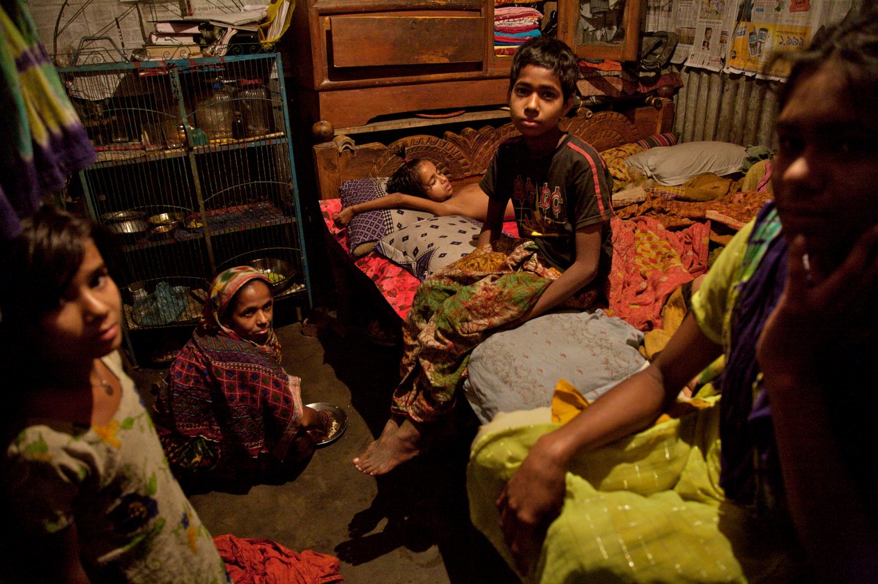 Uma família, na habitação de favela de bambu, perto do rio Buriganga, em Old Dhaka, Bangladesh. 21 de fevereiro de 2007. Até 6 a 10 pessoas vivem em quartos de 10 pés por 10 pés, e compartilham bomba de mão comunitária, banheiro e cozinha entre eles. A mai de Unbekannt Unbekannt