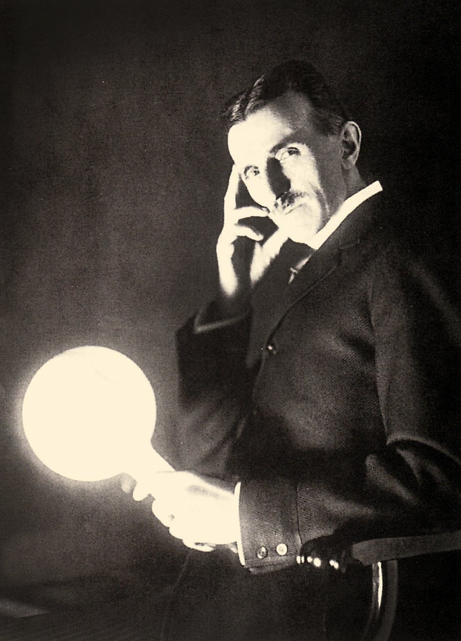 Retrato de Nikola Tesla segurando uma lâmpada iluminada pelo campo eletromagnético de uma bobina de Tesla, 1899 de Unbekannt Unbekannt