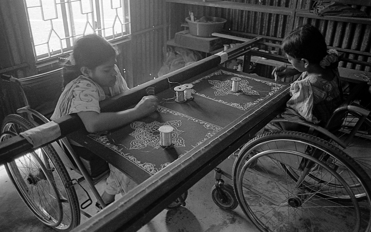 Duas meninas com deficiência física estão engajadas na vestimenta do Centro para a Reabilitação do Paralisado, CRP, em Savar, Dhaka, Bangladesh. 2005. de Unbekannt Unbekannt