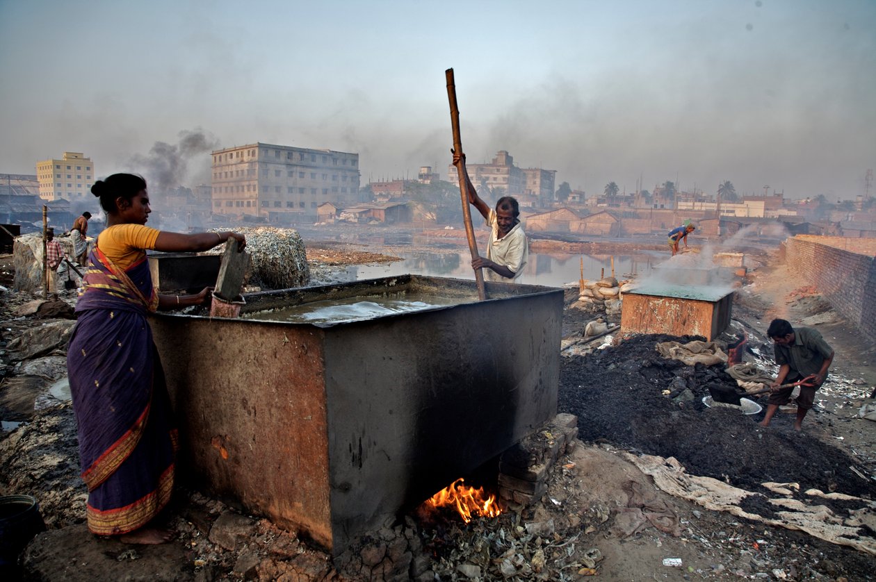 Trabalhadores queimam resíduos de couro para fazer cola, na área de Hazaribagh, ao lado do rio Buriganga, em Dhaka, Bangladesh. Como muitos outros setores despreocupados com os fatores ambientais, os curtumes também causam sérios danos ao meio ambiente. Ha de Unbekannt Unbekannt