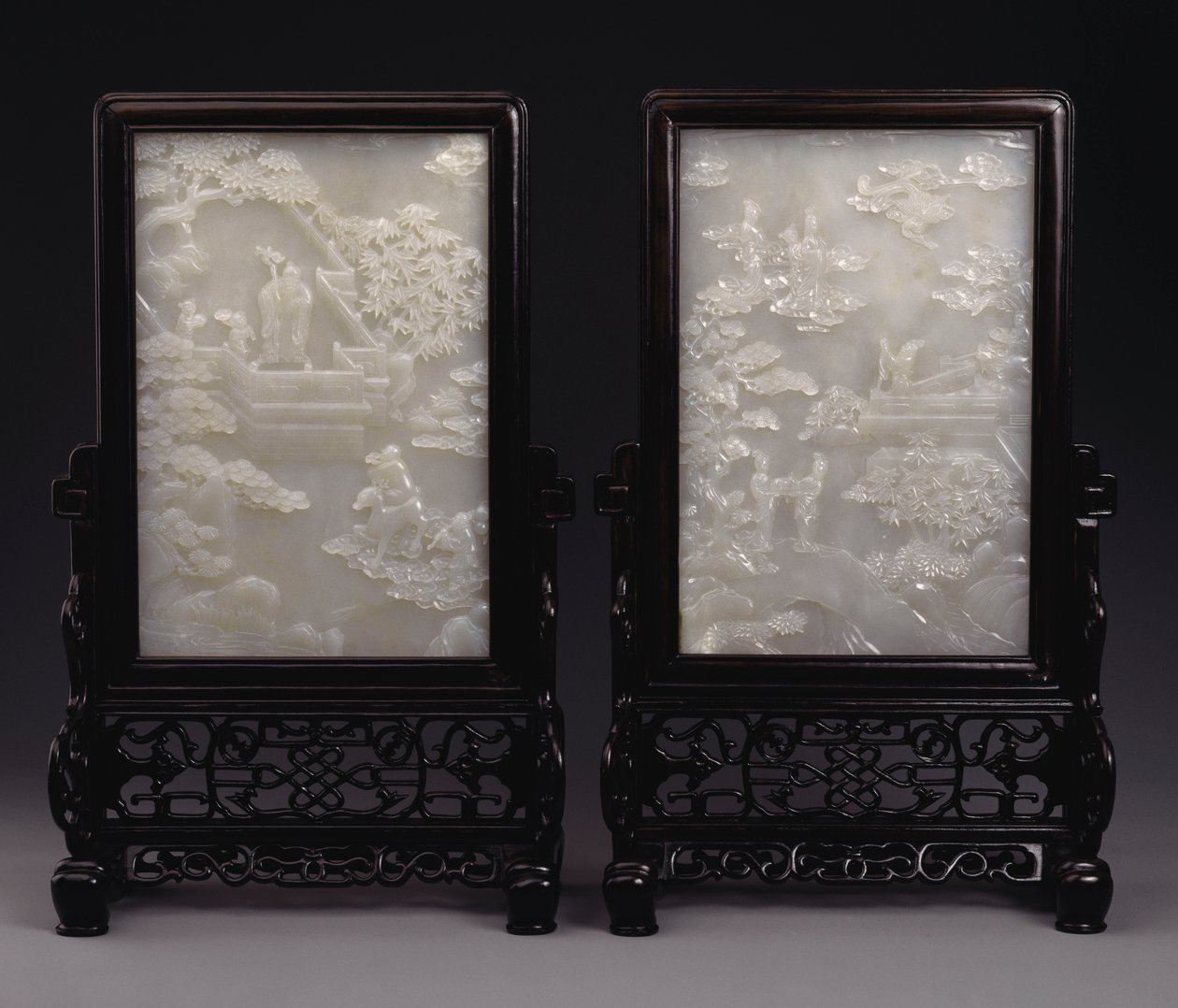 Um par de telas de mesa de jade branco esculpidas em relevo com imortais entre nuvens ou em jardins com assistentes e bestas míticas de Unbekannt