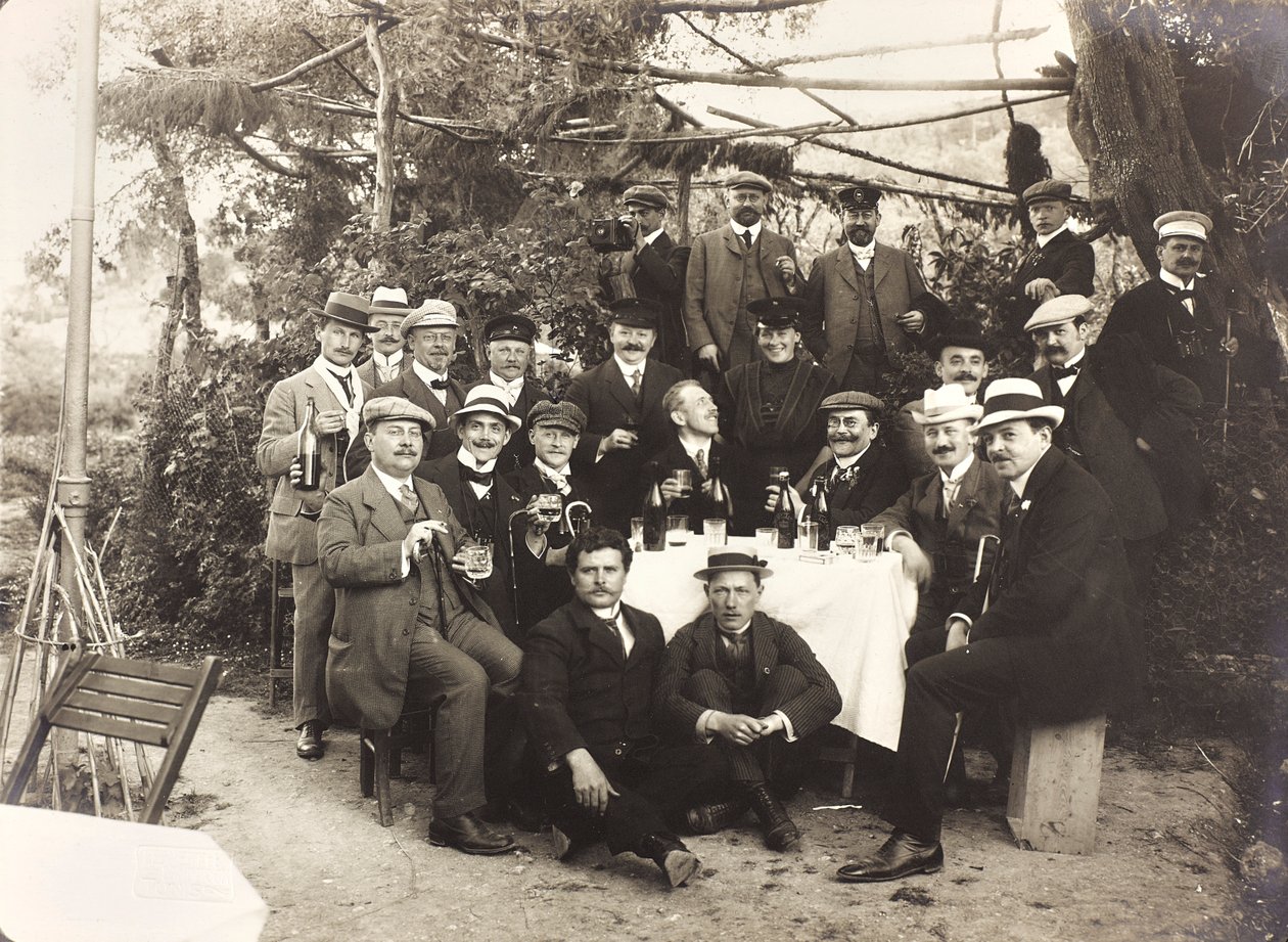 Álbum "Meine mittelmeer-reise 1910": Grupo de pessoas a posar enquanto fazem um brinde num jardim de Unbekannter Künstler