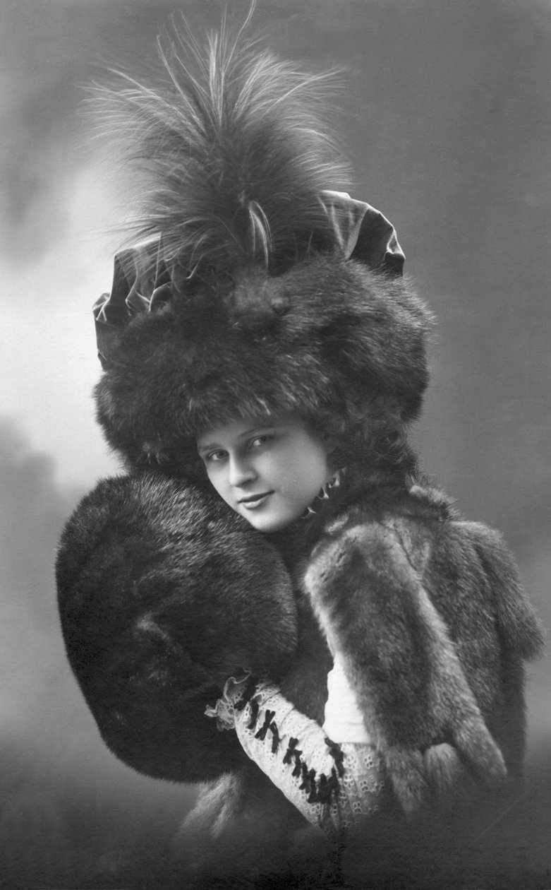 Moda: uma jovem mulher em pele (casaco, chapéu de penas e manga). Annees 1920-1930 Fotografia histórica de moda, modelo feminino de Unbekannter Künstler