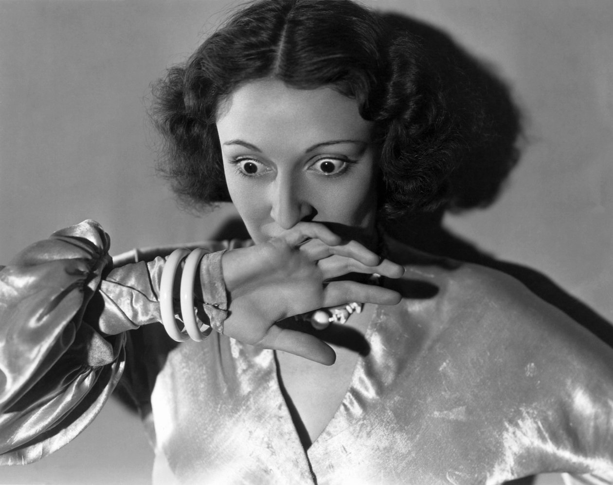 Hollywood, Califórnia: c.1932 Grande plano de uma jovem mulher cobrindo a boca com medo. (foto a p/b) de Unbekannt