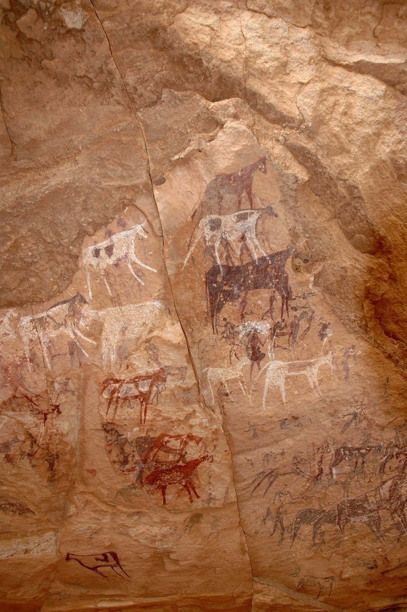 Arte rupestre, Pré-história: Pintura rupestre de um grupo de gado e personagens em um abrigo ornamentado, no maciço de Uweinat, Sudão (Karkur-Talh ou Karkur Talh). Período de 8000 a 3000 anos antes de Cristo. Fotografia de Unbekannt