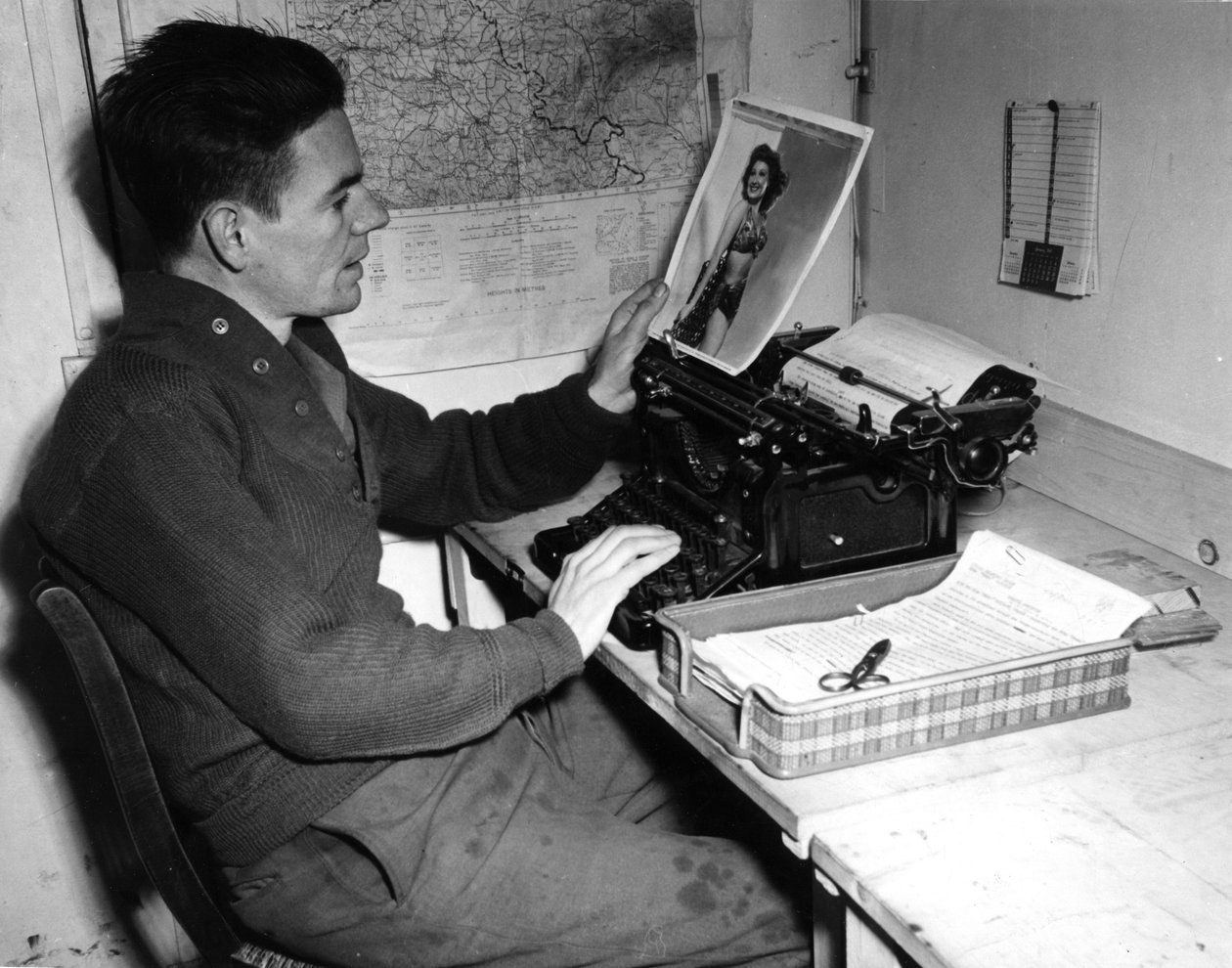 Segunda Guerra Mundial (1939-1945) - Segunda Guerra Mundial (II Guerra Mundial ou 2ª Guerra Mundial): Mutzig (Alsácia) França, 1 de Dezembro de 1944: O cabo Flanerty, cronista do Beachead News (jornal de notícias da GI), vê uma fotografia que publica na pr de Unbekannt