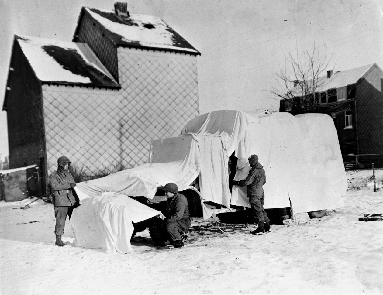 Segunda Guerra Mundial (1939-1945) - Segunda Guerra Mundial (II Guerra Mundial ou 2ª Guerra Mundial): Perto de Bastogne (Bélgica), no final de Dezembro de 1944: Estes soldados americanos usam lençóis brancos para esconder um camião aos olhos do inimigo. de Unbekannt