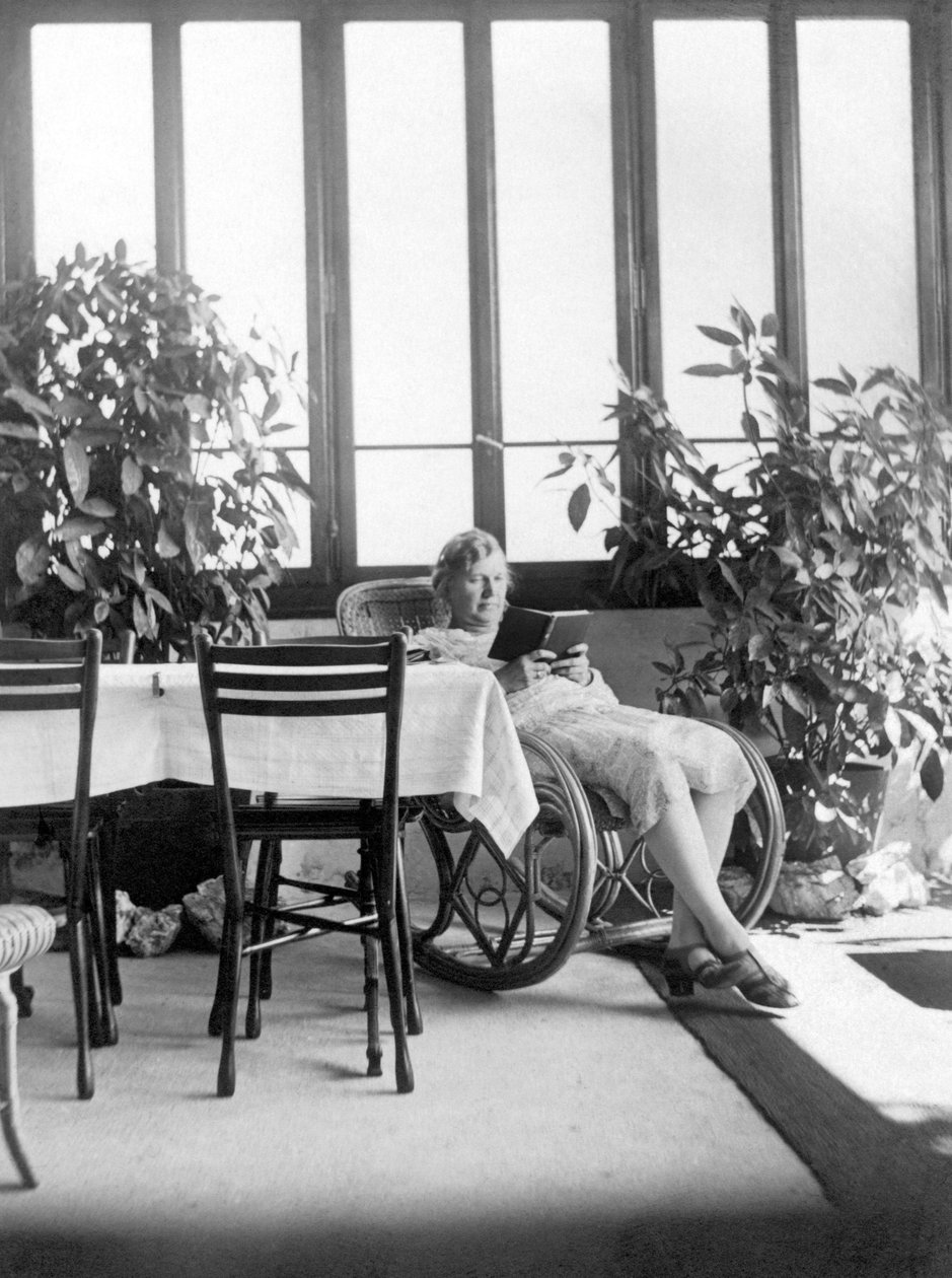 Mulher sentada numa cadeira de baloiço, a ler um livro. 1915 aprox. Alemanha Fotografia histórica, mulher a ler, ca. 1915 de Unbekannter Künstler