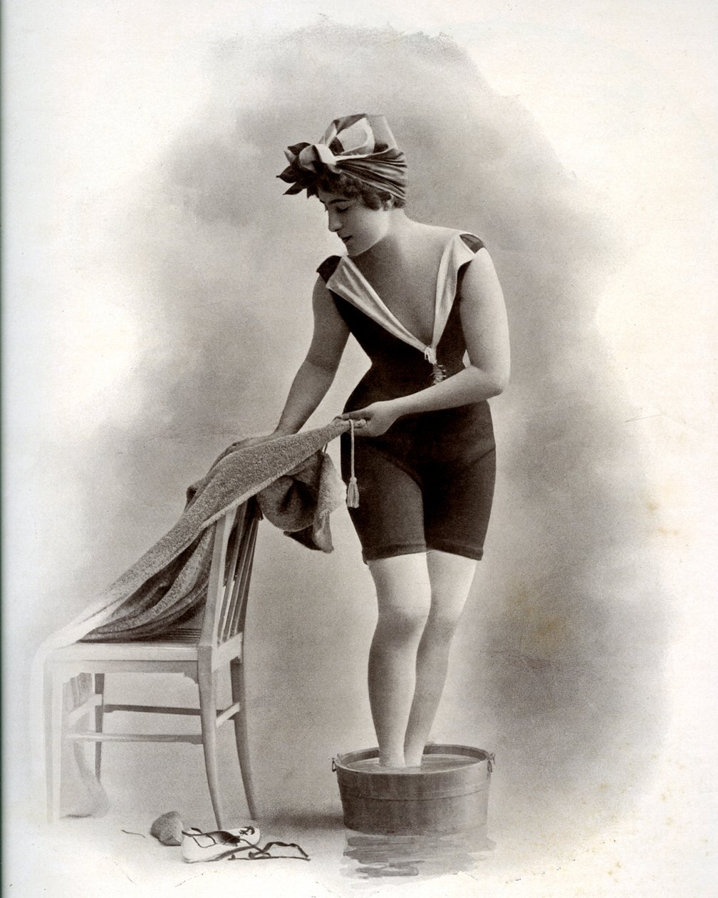 Jovem mulher em fato de banho (da Belle Epoque) a tomar banho de pés, por volta de 1900 (foto a p/b) de Unbekannter Künstler