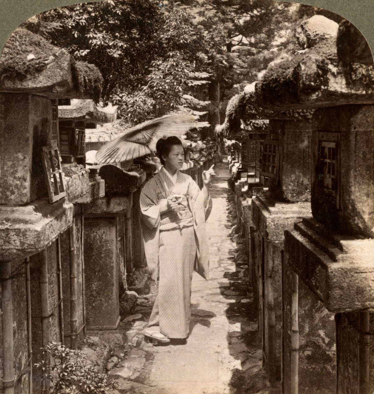 Uma mulher xintoísta devota contando as lanternas de pedra, Kasuga Shrine, Nara, Japão, 1904. de Underwood and Underwood