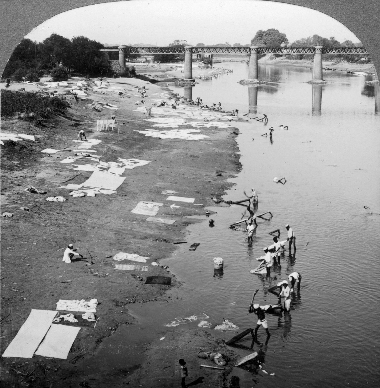 Dbobies lavando roupas no rio Goomti, perto de Lucknow, Índia, em 1900. de Underwood and Underwood