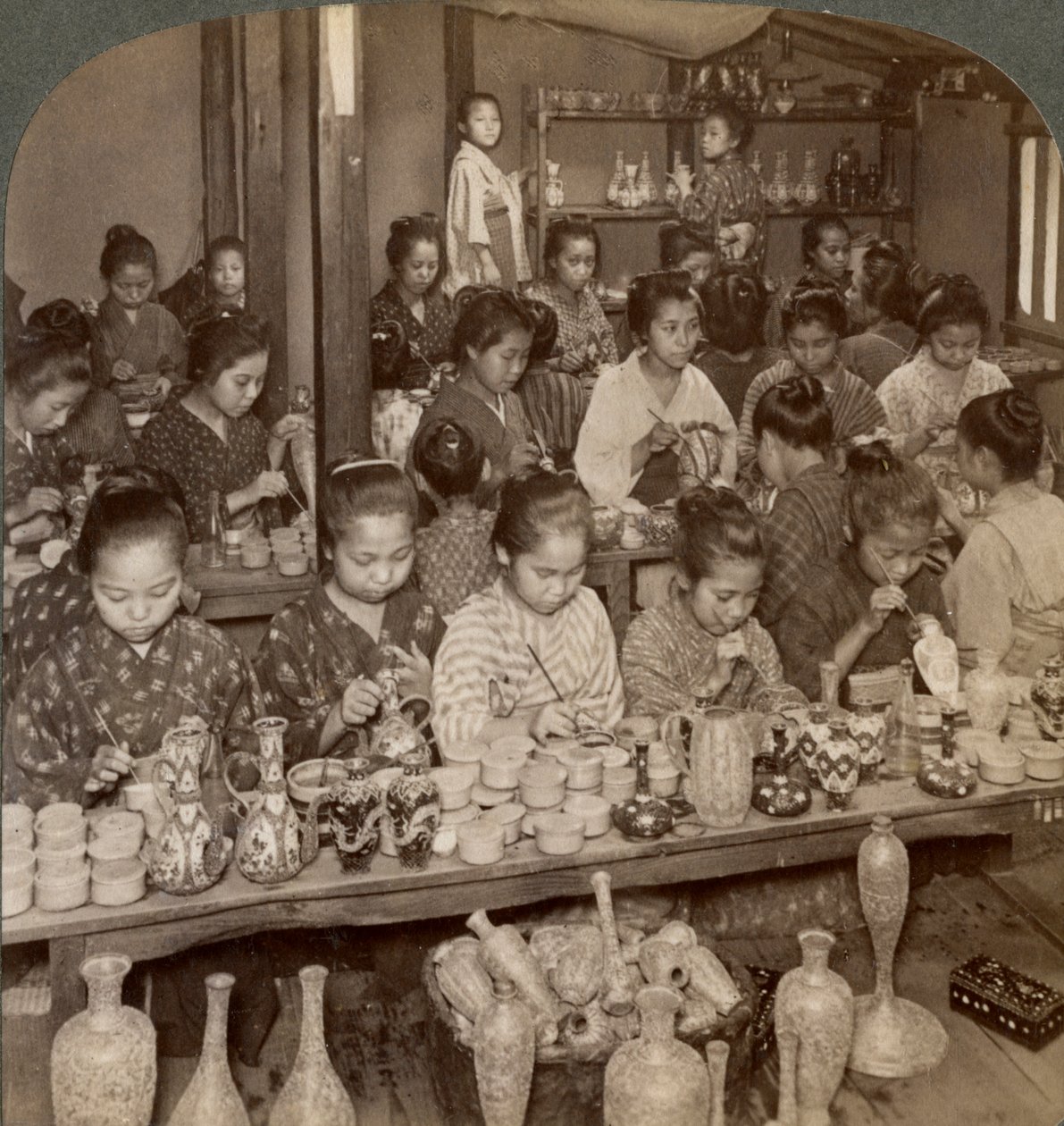 Meninas de fábrica decorando cerâmica barata para o mercado externo, Kyoto, Japão, 1904 de Underwood and Underwood