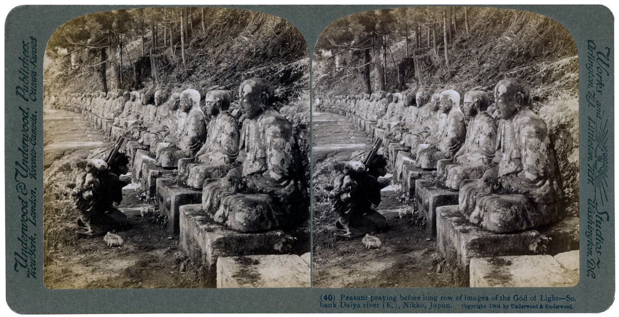 Camponês rezando diante de uma fileira de estátuas do Deus da Luz, rio Daiya, Nikko, Japão, 1904. de Underwood and Underwood