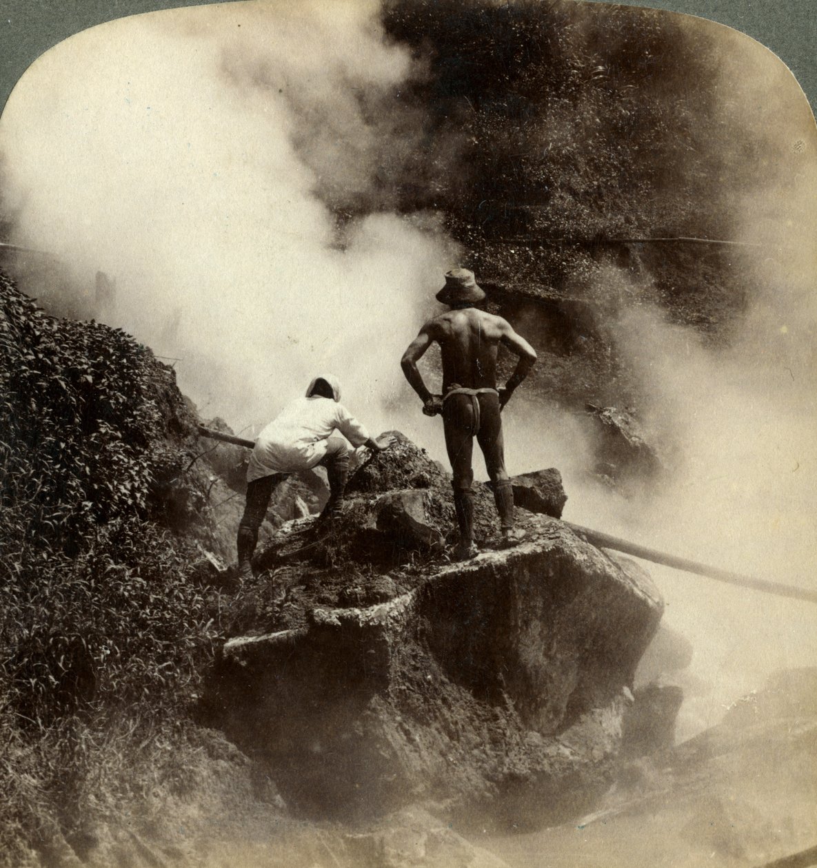 Assistindo a uma erupção de vapor e lama fervendo no meio do vulcão Aso-san, Japão, 1904 de Underwood and Underwood