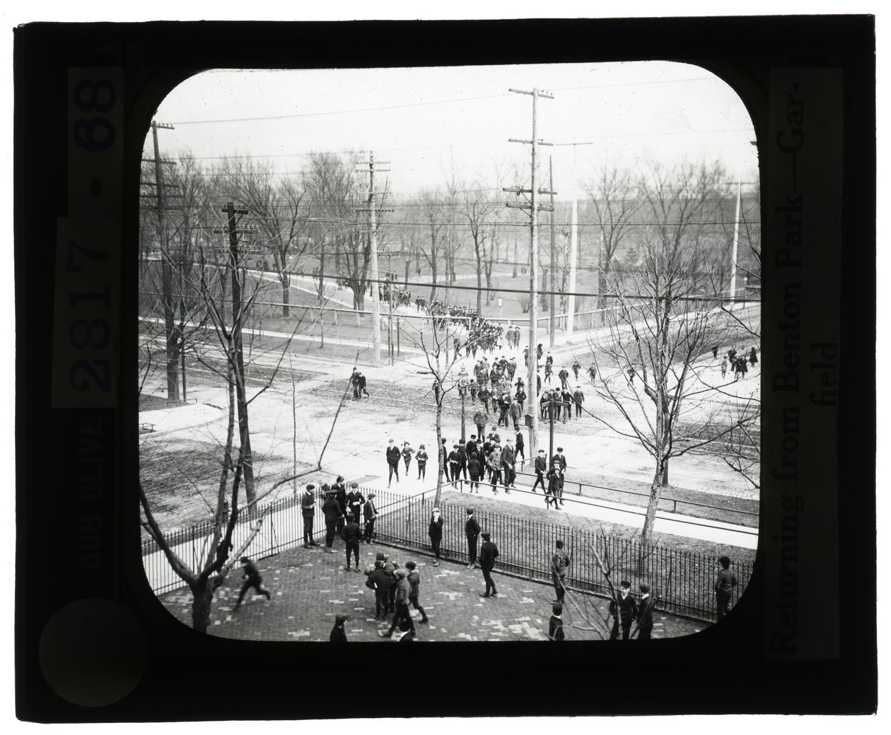 Foto horizontal, preto e branco de meninos e meninas atravessando a rua para retornar à escola de uma viagem para o parque de Unknown