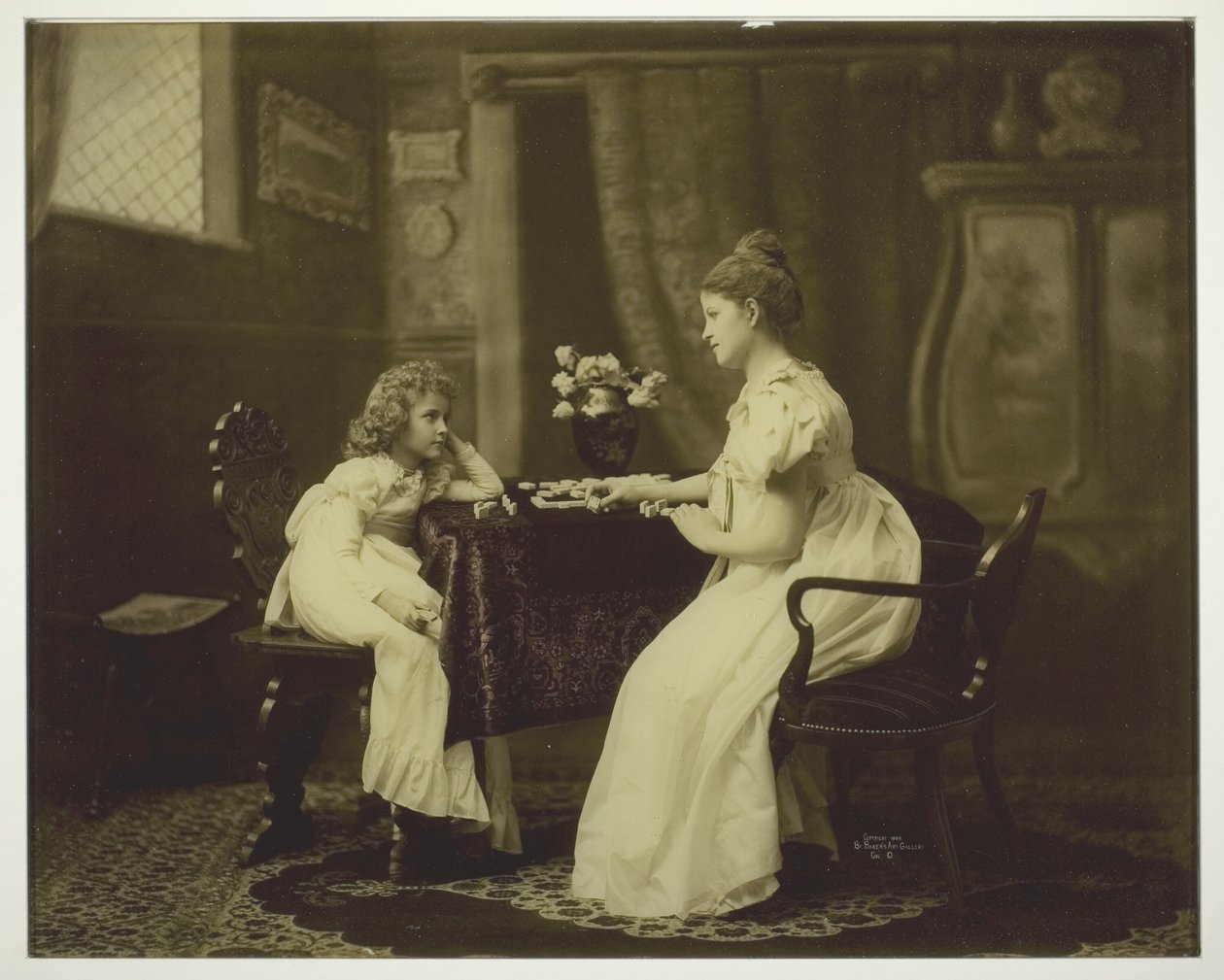 Mulher e criança jogando dominó na mesa de Unknown