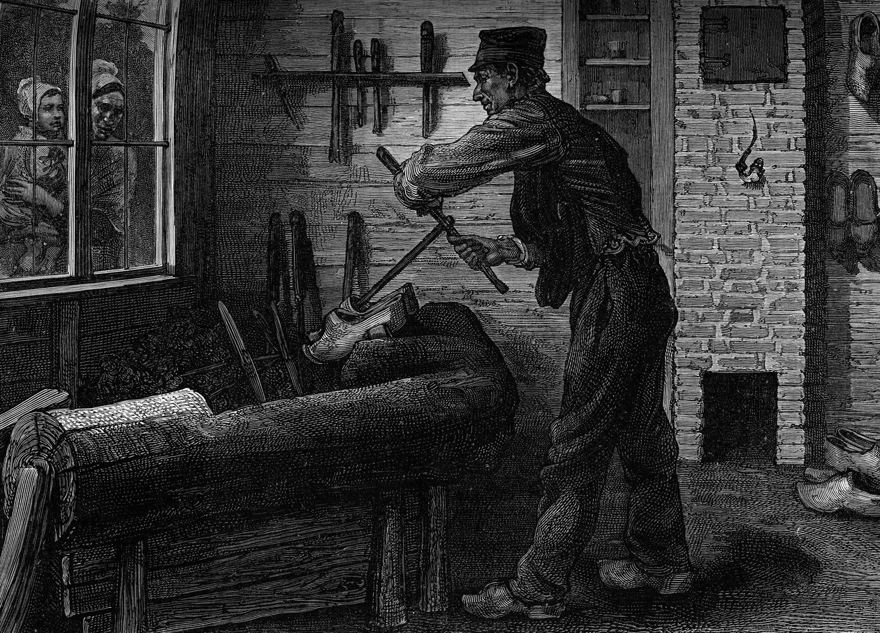 Um sabotier a trabalhar na sua oficina na Bélgica, gravando na revista "la jeunesse". de Unknown artist