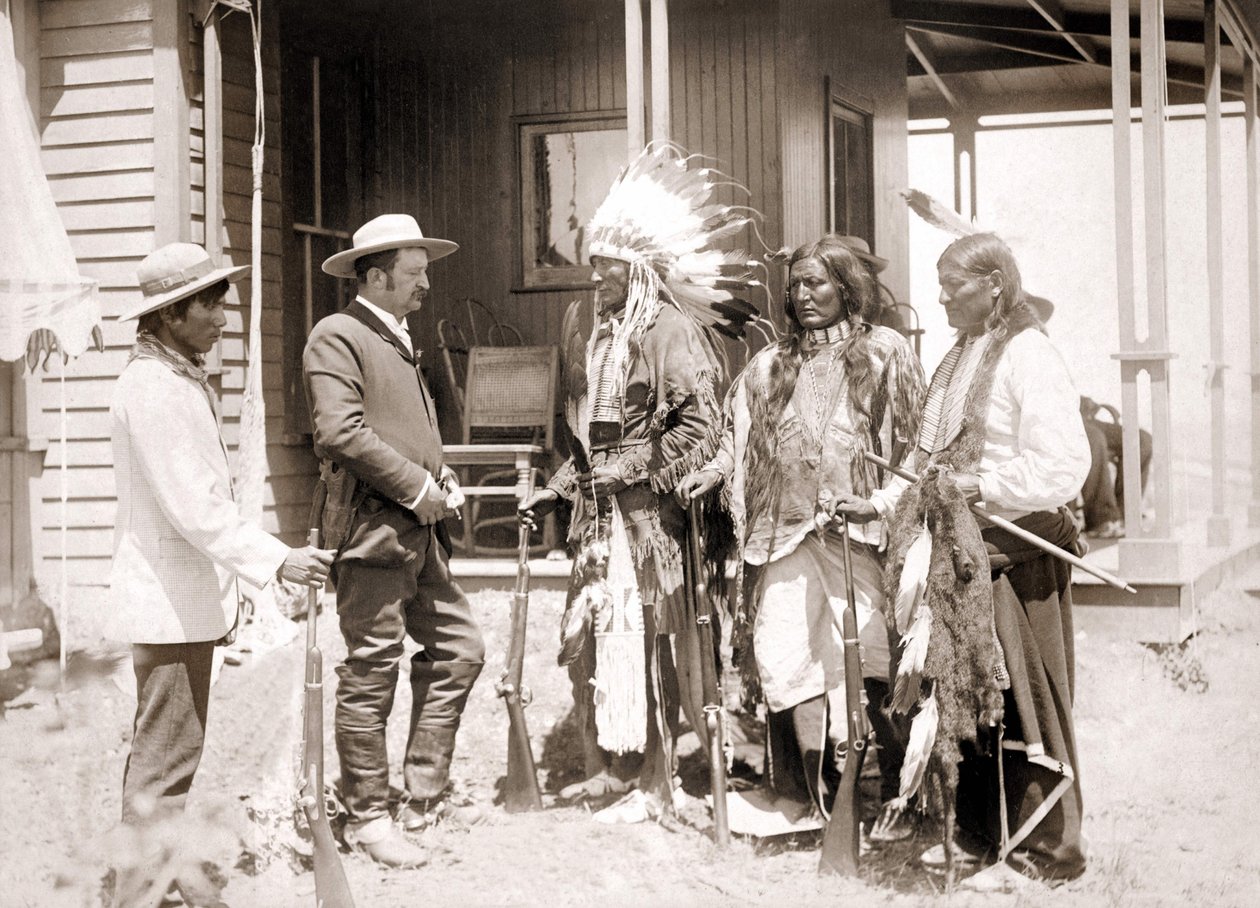 Três Cheyenne vestidos com trajes cerimoniais e armados cumprimentam um branco acompanhado por um intérprete. sd. final do século XIX de Unknown artist