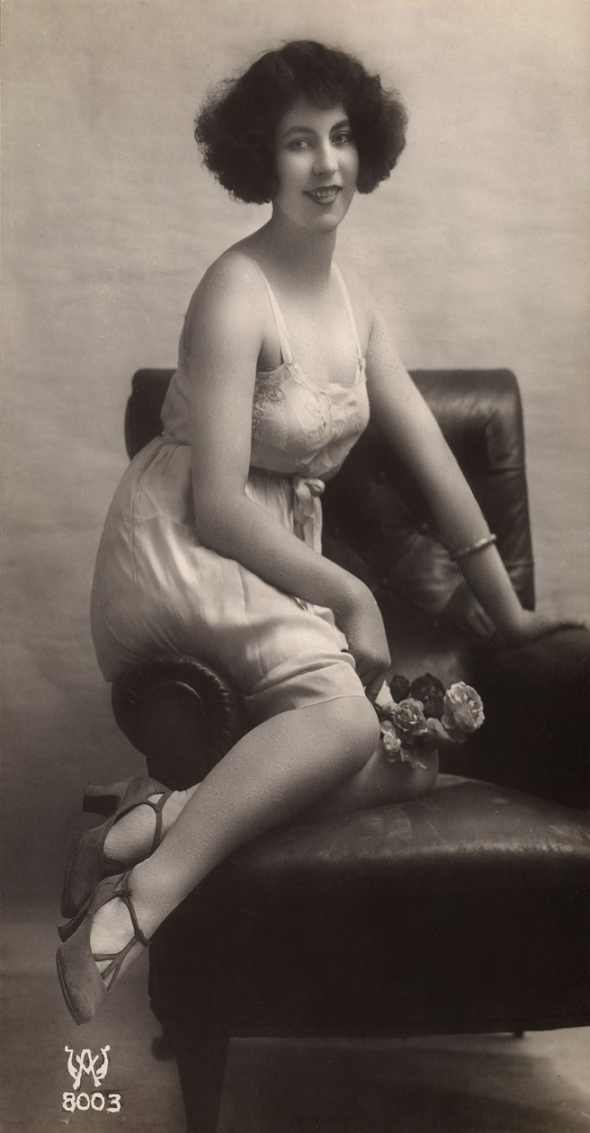 Uma jovem mulher posando com o seu saiote, sentada numa poltrona de Unknown photographer
