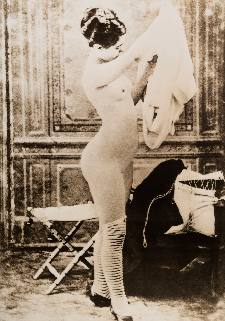 Retrato a corpo inteiro de uma jovem mulher nua a vestir-se. de Unknown photographer