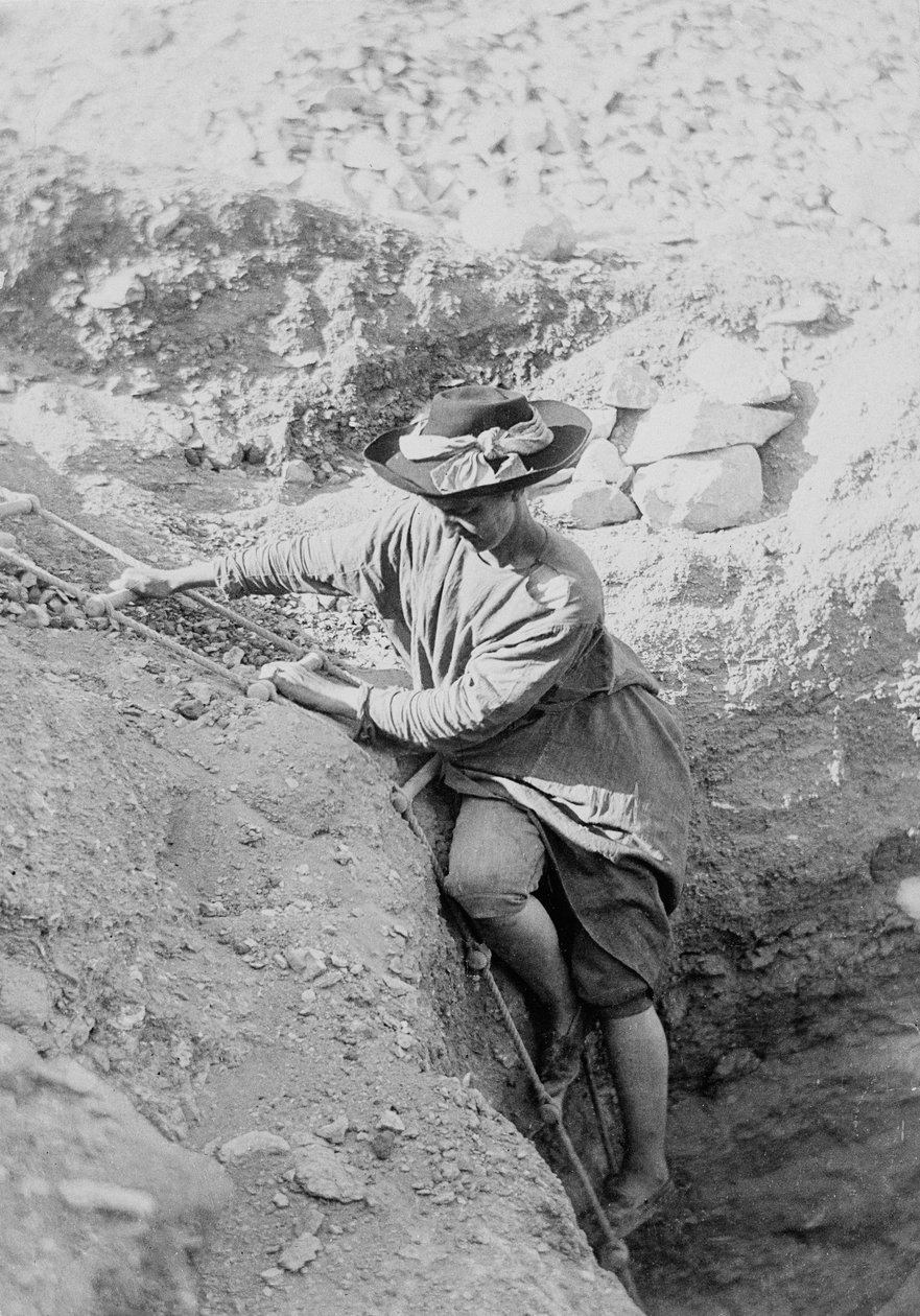 Hilda Petrie (née Urlin) descendo por uma escada de corda até um túmulo, Possivelmente em Denderah de Unknown photographer