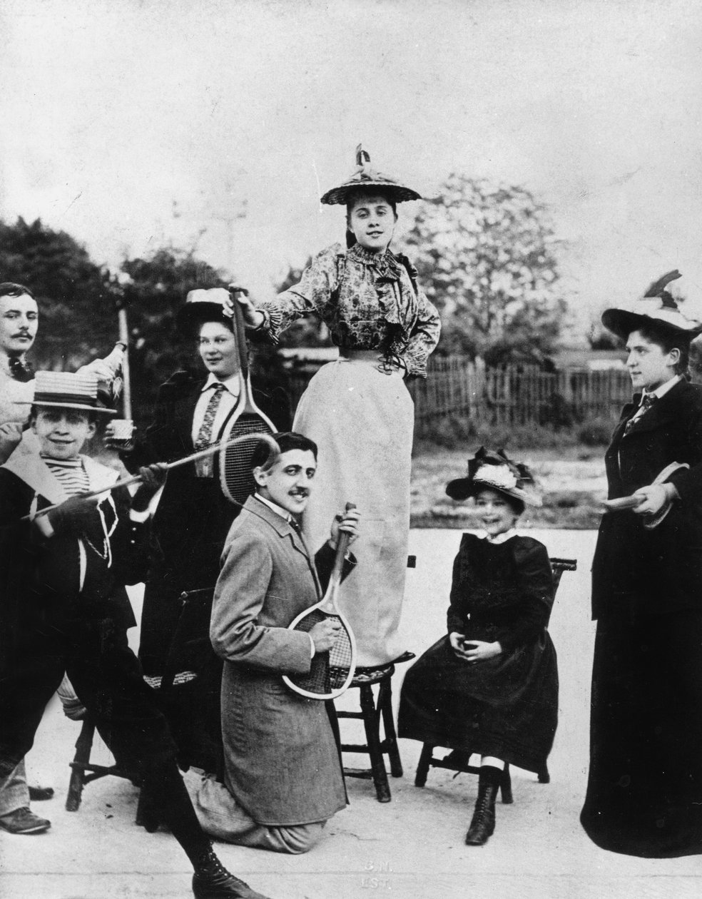 Marcel Proust (1871-1922) ajoelhado com uma raquete de ténis em frente de Jeanne Ponquet em pé numa cadeira em Neuilly (França) 1892 de Unknown photographer