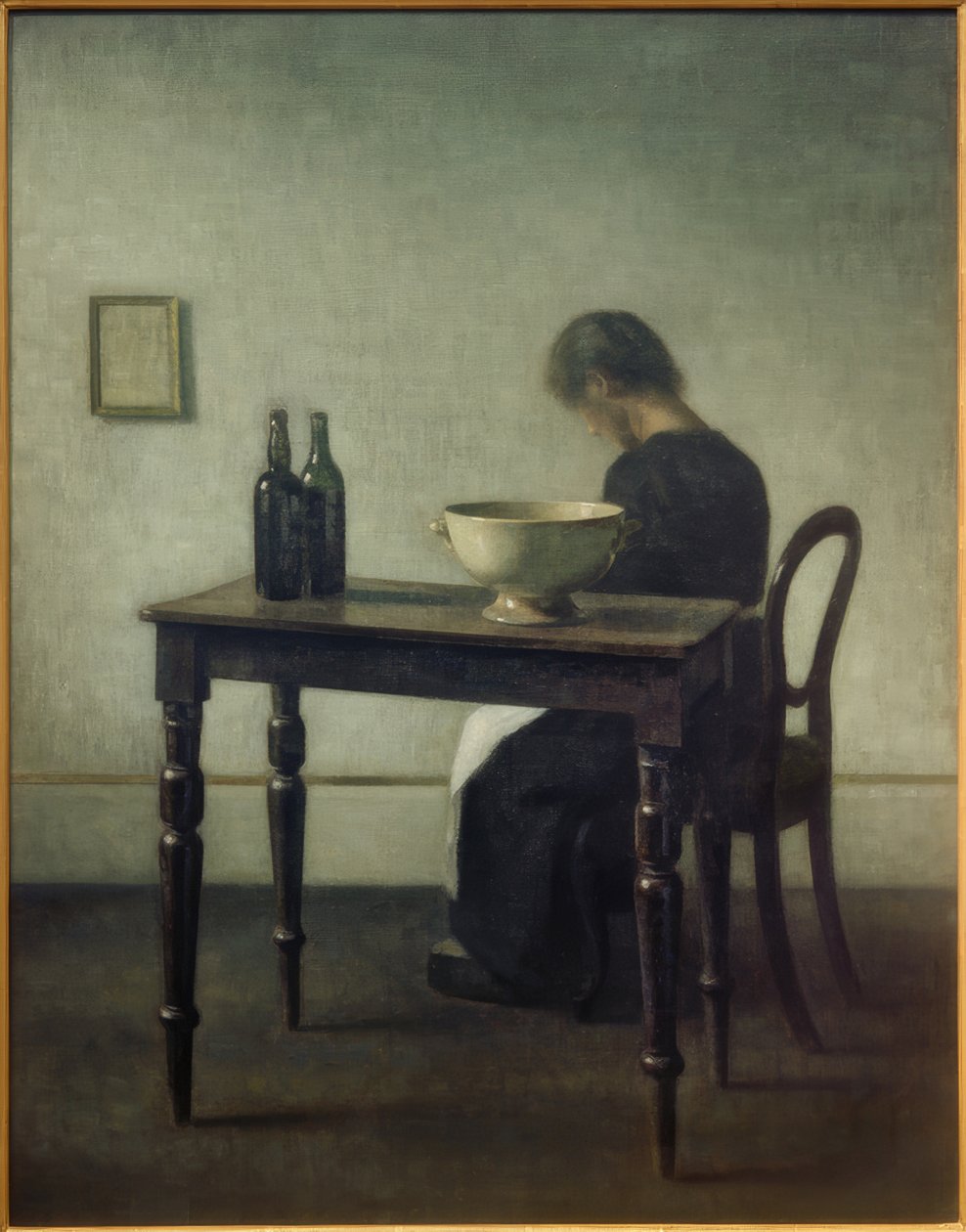 Mulher sentada atrás de uma mesa de Vilhelm Hammershoi