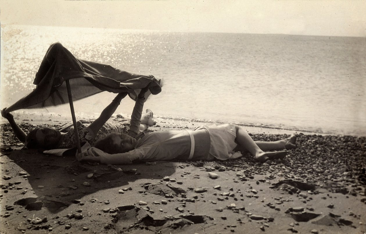 Duas mulheres deitadas à beira-mar, à sombra de uma toalha. Postal enviado pelo fotógrafo a Vincenzo Balocchi de Vincenzo Balocchi