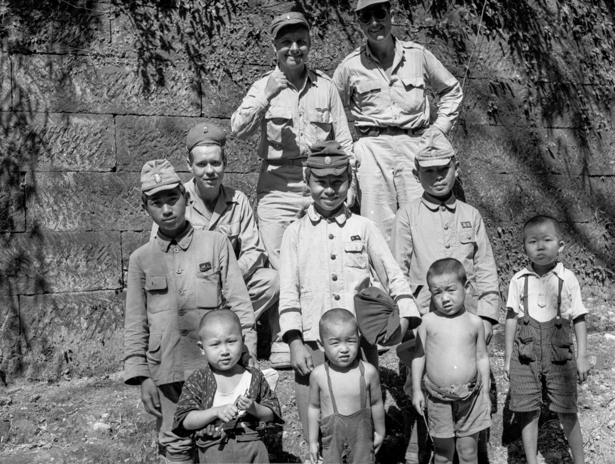 Soldados americanos e família japonesa posam juntos após a rendição japonesa e... de Volkmar Wentzel